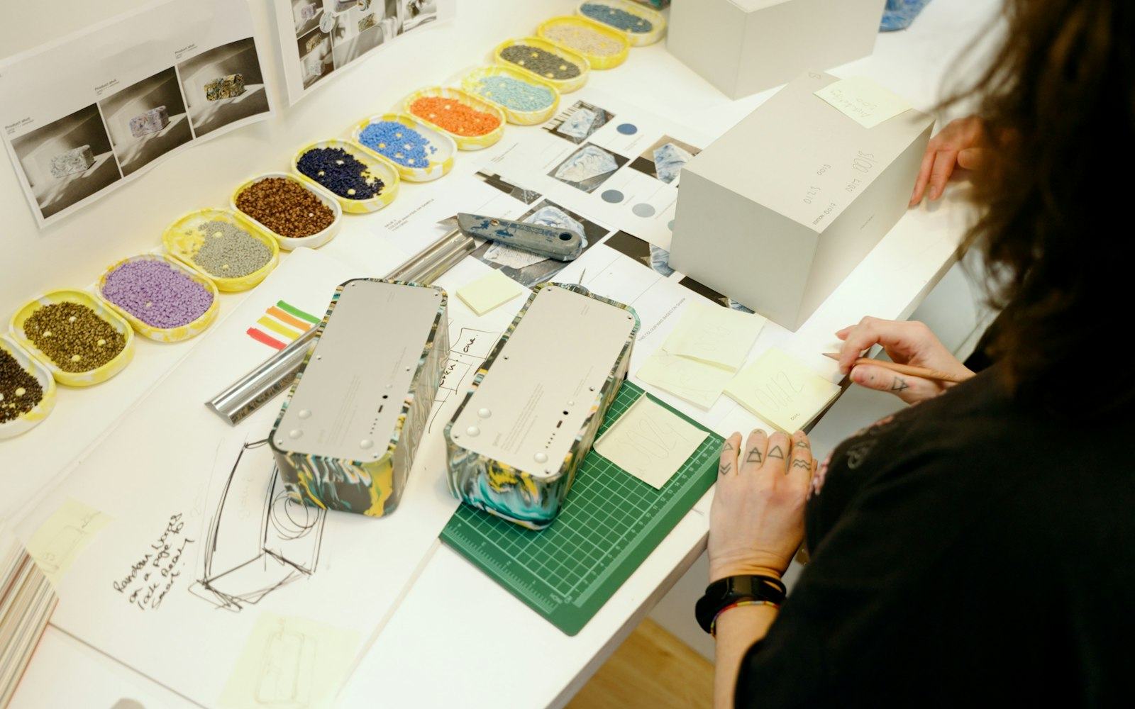 A designer at a worktable, arranging colour and material samples